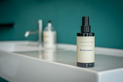 KatriNaturals Rosenwasser mit Waschbecken im Hintergrund