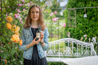 Rosenwasser in der Hand gehalten in einem Rosengarten