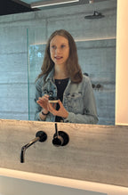 Spiegelbild mit Cremetiegel in der Hand gehalten